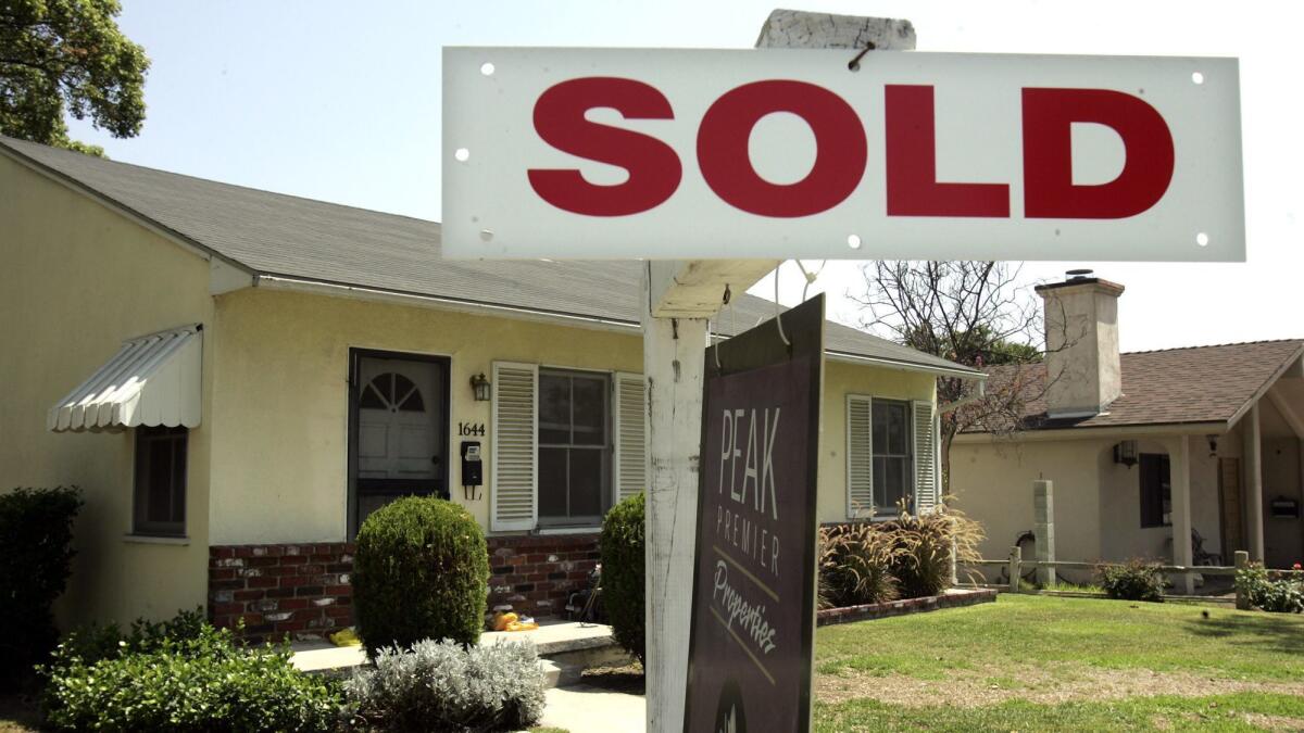 Photo of a "sold" sign outside a home.