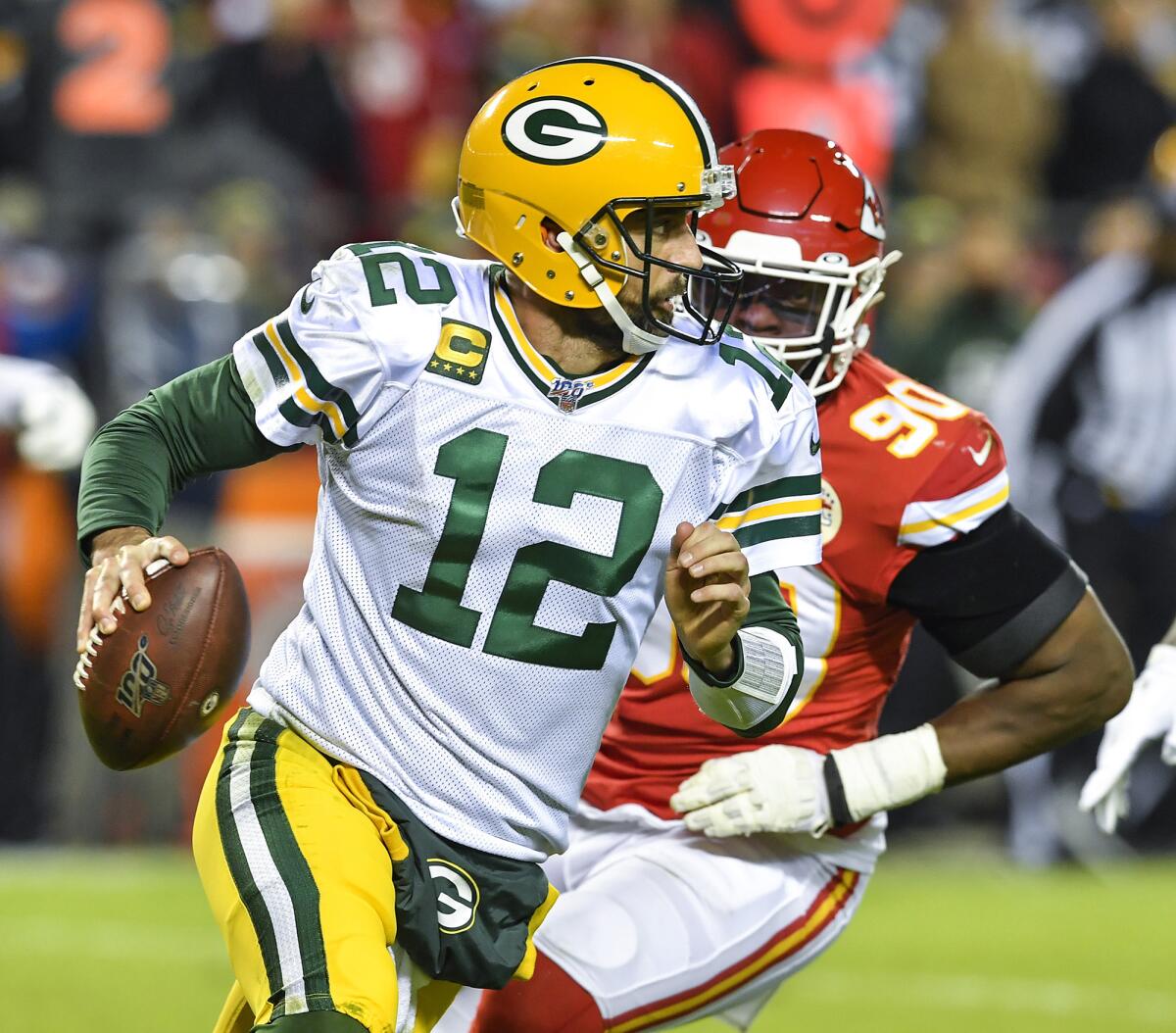 Green Bay Packers quarterback Aaron Rodgers (12) is chased out of the pocket in the second quarter by Kansas City Chiefs defensive end Emmanuel Ogbah in Kansas City, Mo., on Oct. 27, 2019.