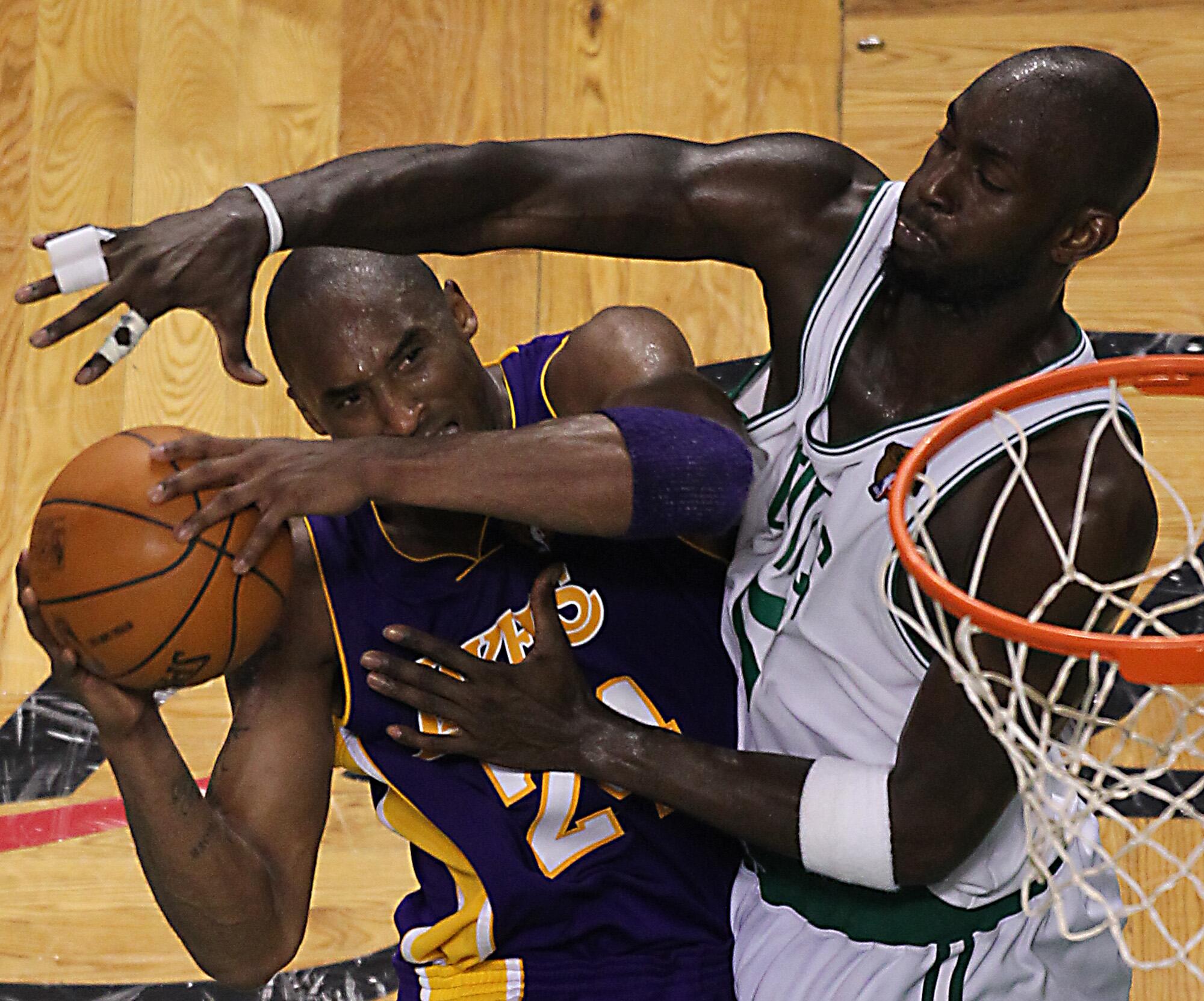 Lakers star Kobe Bryant has his layup challenged by fellow Hall of Famer Kevin Garnett during a game against the Celtics.