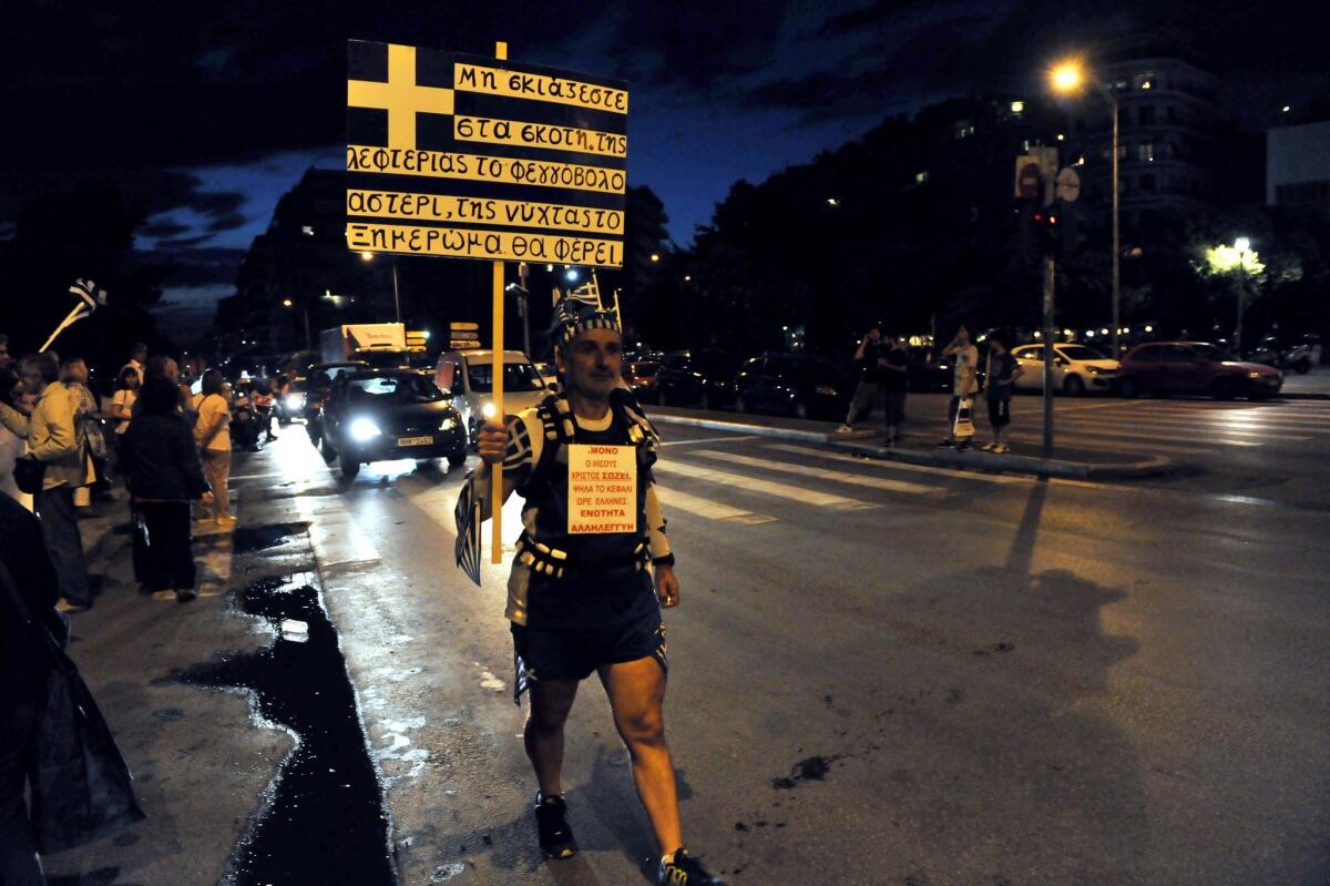 A demonstrator carries a Greek flag in Thessaloniki during a protest against EU austerity policies and in support of the Greek government on 17 June, 2015.