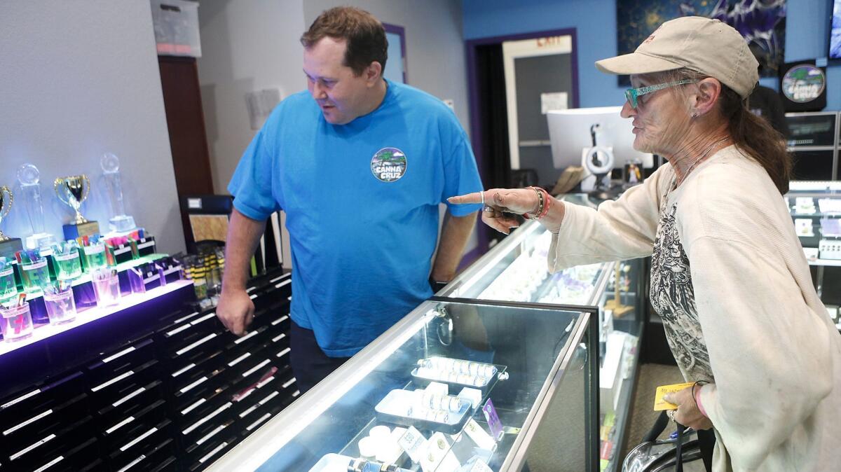 Grant Palmer, left, helps Hope Parks with purchases at the Canna Cruz medical cannabis dispensary in Santa Cruz, Calif.