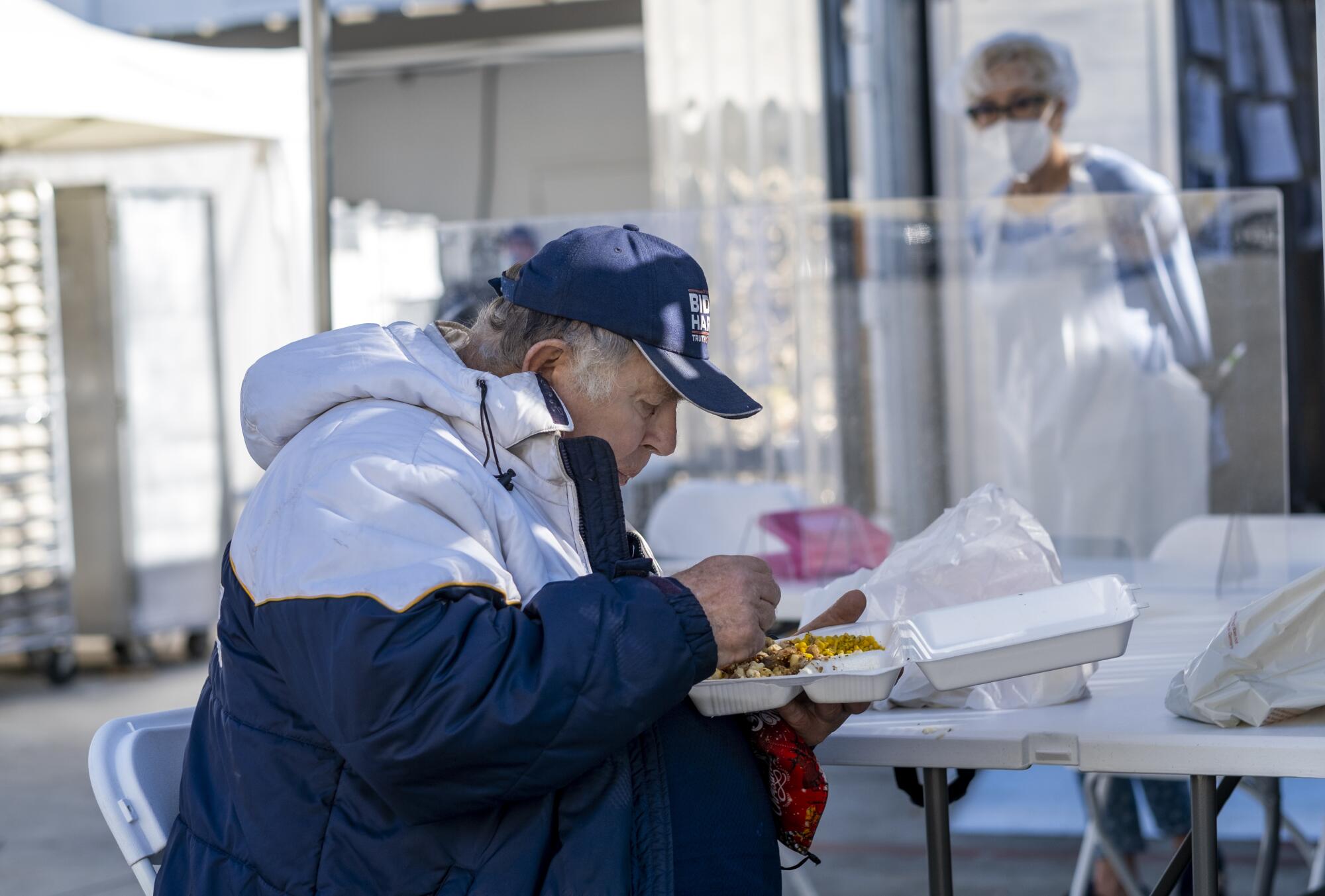 A man eats a meal outdoors. 