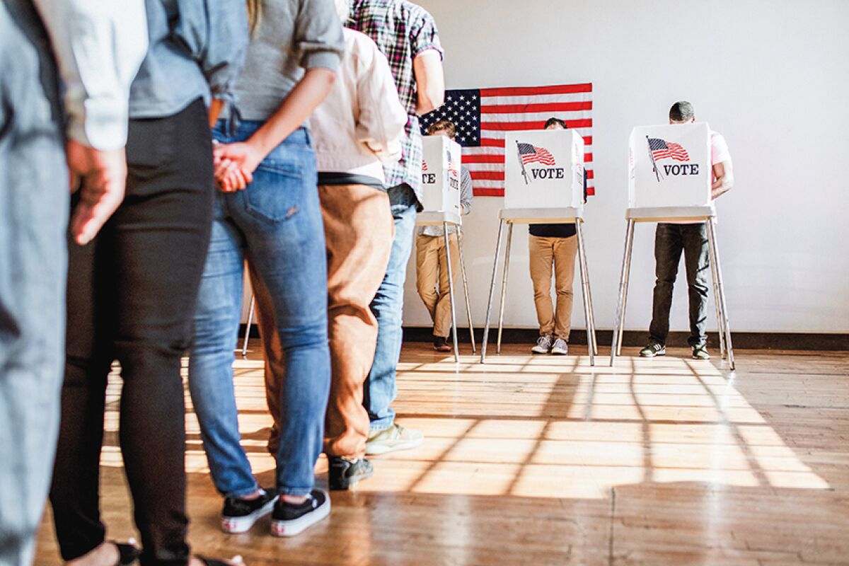 People wait in line to vote at a polling place