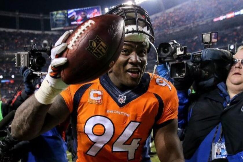 Broncos outside linebacker DeMarcus Ware (94) walks off the field smiling and holding a football after recovering a fumble to end a game against the Bengals on Dec. 28.