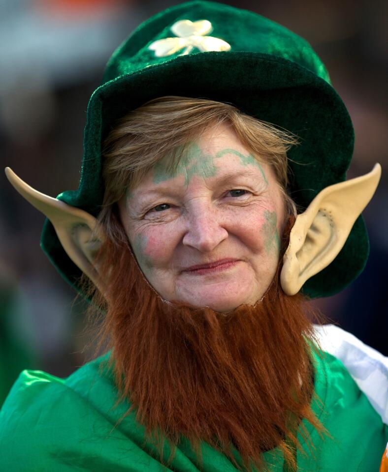 A woman wearing a leprechaun costume attends a St. Patrick's Day parade in Central London.