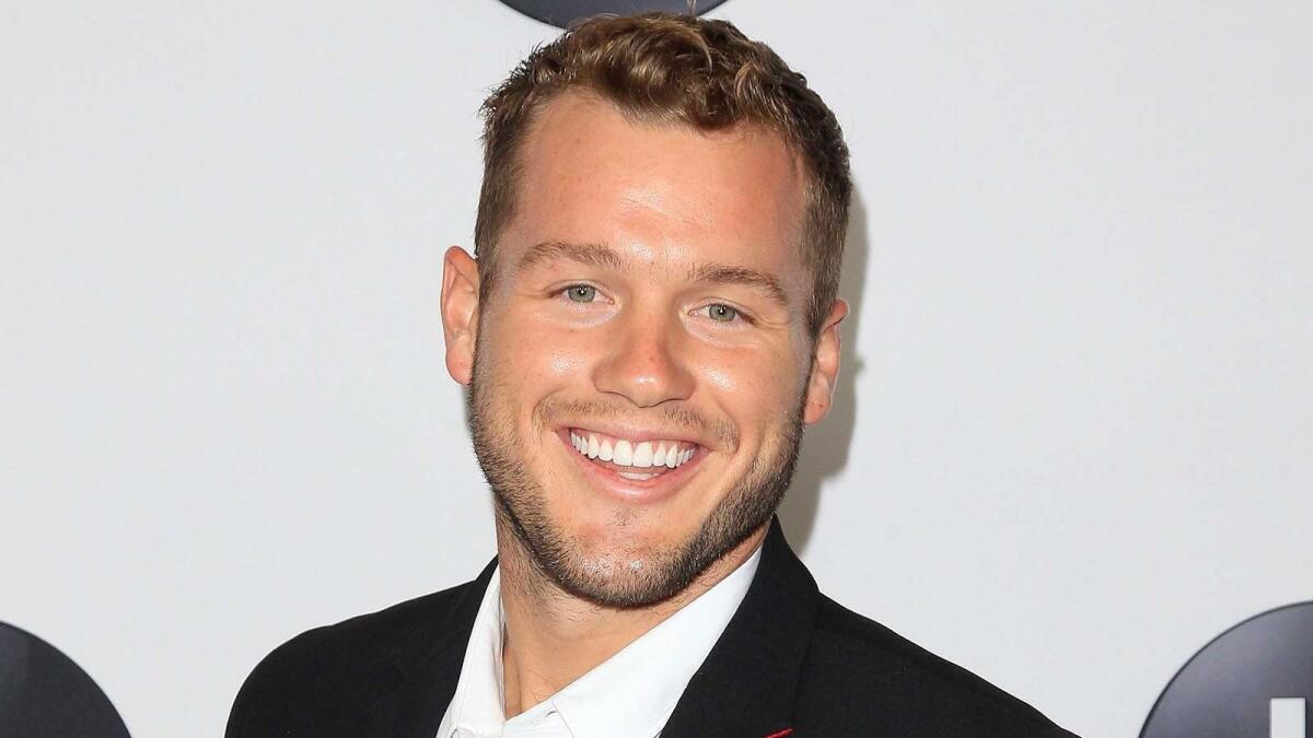 Colton Underwood smiling in a suit.