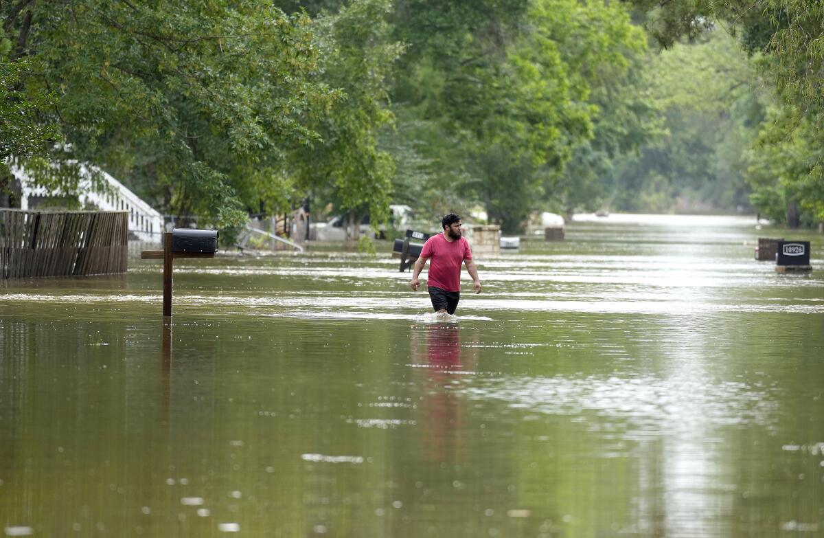 A man walks through floodwaters in Woodloch, Texas.