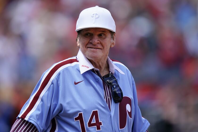 Former Philadelphia Phillies player Pete Rose walks onto the field for an alumni day event.