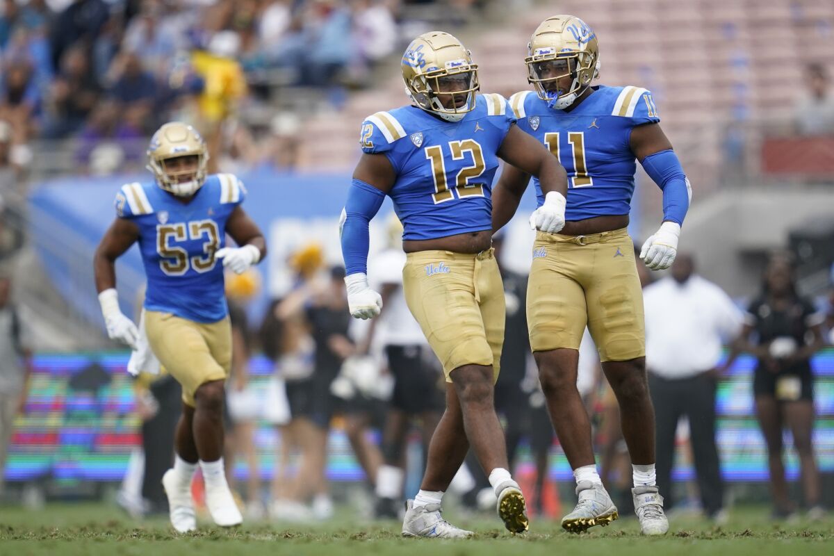 UCLA defensive linemen Grayson (12) and Gabriel Murphy (11) celebrate after a sack against Alabama State.