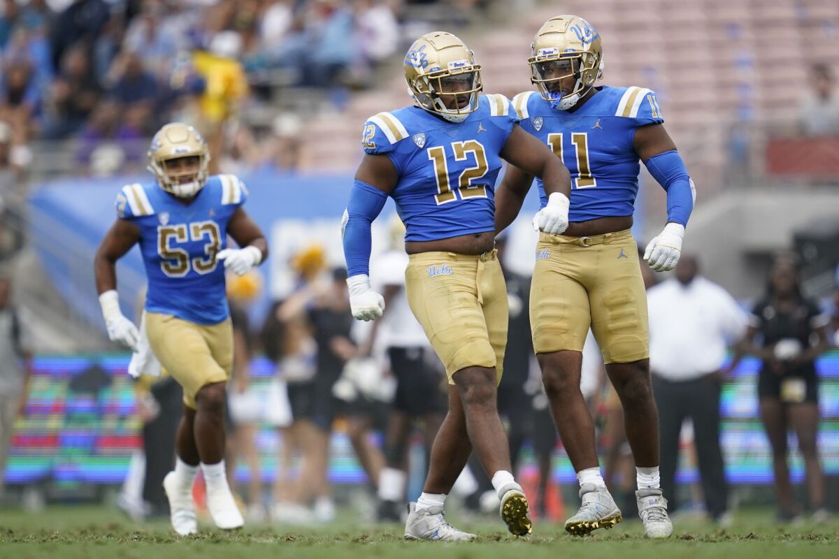 Les joueurs de ligne défensive de l'UCLA Grayson (12) et Gabriel (11) Murphy célèbrent après un sac contre Alabama State.