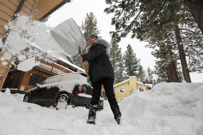 BIG BEAR LAKE, CA - FEBRUARY 28: Amblerlee Barden shovels snow after successive storms dumped several feet of snow blocking her driveway on Tuesday, Feb. 28, 2023 in Big Bear Lake, CA. (Brian van der Brug / Los Angeles Times)