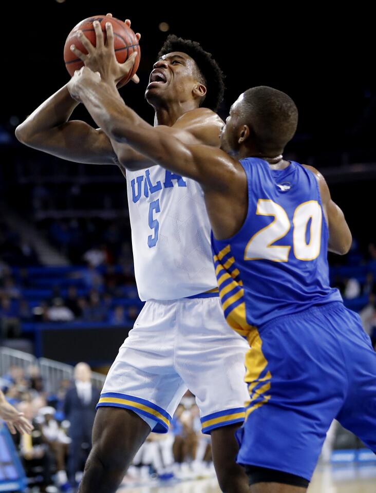 UCLA forward Chris Smith is fouled by Hofstra guard Jalen Ray.