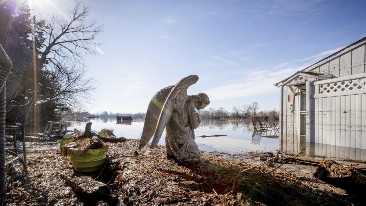 An angel statue March 22 in a yard near Hansen Lake in Bellevue, Neb. Residents were allowed into the area for the first time since floodwaters overtook several homes.