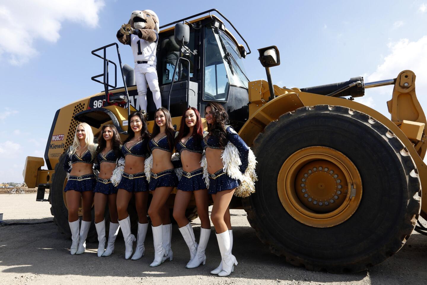 Rams cheerleaders and mascot pose next to a bulldozer at a groundbreaking ceremony for the team's new stadium in Inglewood on Nov. 17, 2016.