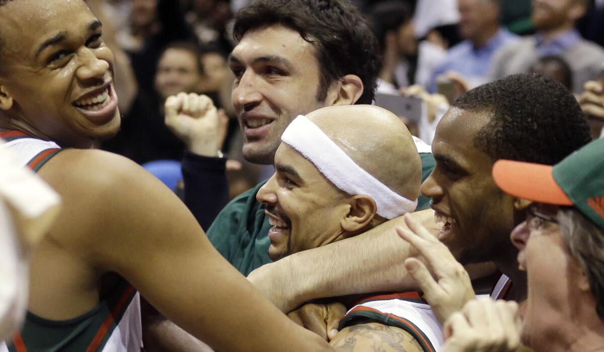 Milwaukee's Jerryd Bayless, center, is swarmed after making the game-winning basket Saturday against Chicago.