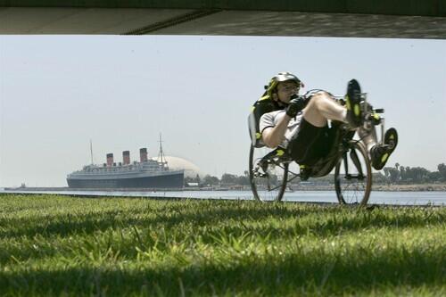 With the Queen Mary as backdrop, Jonathan Dietch zips along on his recumbent in the Long Beach leg of the Los Angeles River bike path. The cycle's low, reclining position helps take the pressure off the neck, back and wrists.