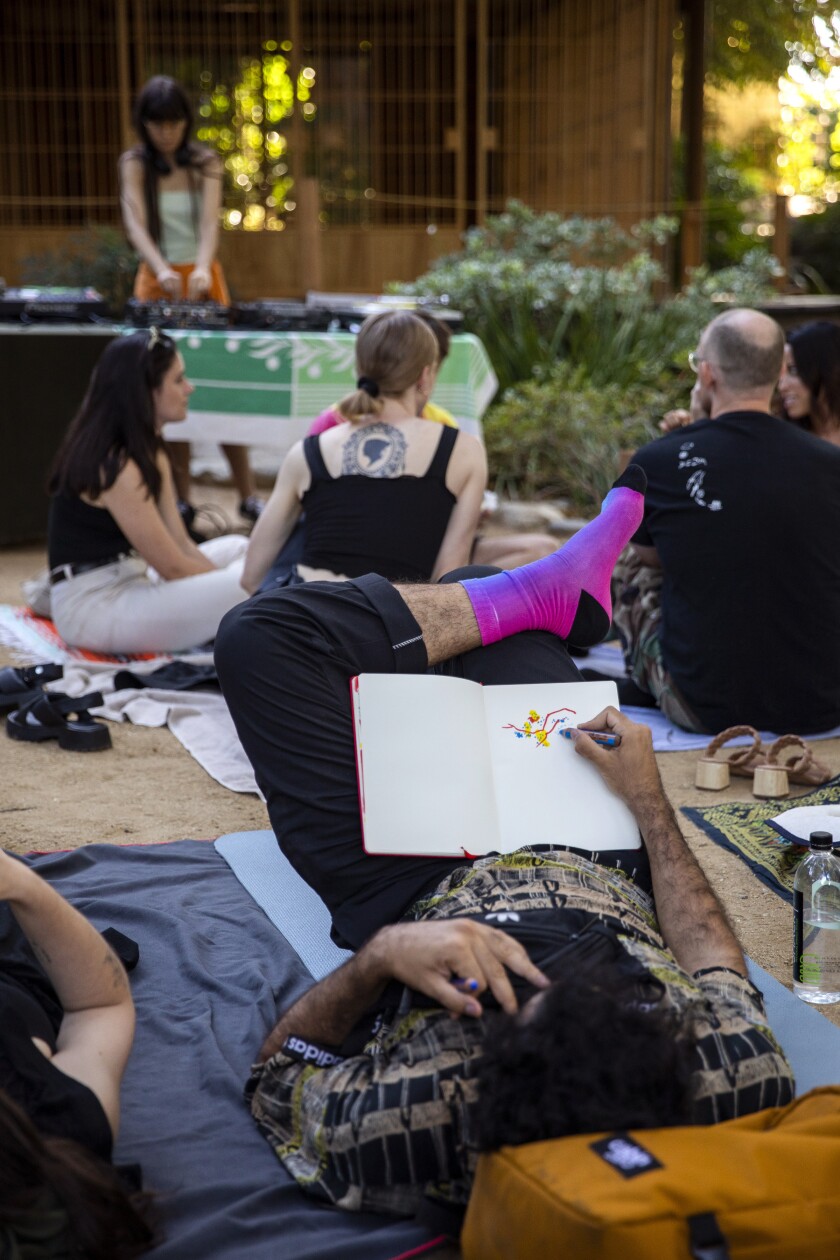 People chat, read, relax, draw and eat together while listening to music at a floating event