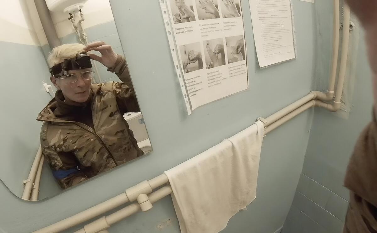 La médica Yuliia Paievska, conocida como Taira, se mira en el espejo y apaga su cámara en Mariúpol, 