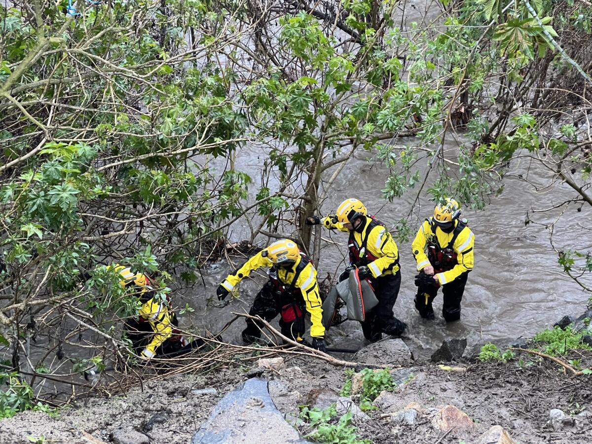 Orange County Fire Authority swift water rescue team members set up in a Laguna Hills creek.