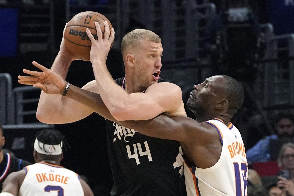 Clippers center Mason Plumlee protects the basketball from the reach of Suns center Bismack Biyombo during a playoff game.