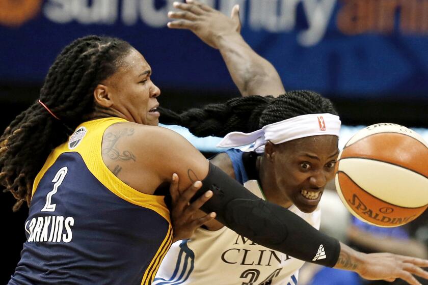 Fever forward Erlana Larkins, left, tries to keep Lynx center Sylvia Fowles from getting to a loose ball in the second half of their WNBA Finals game Sunday.