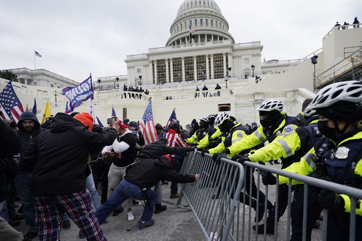 FILE - Insurrectionists loyal to President Donald Trump try to break through a police barrier, Wednesday, Jan. 6, 2021, at the Capitol in Washington. David Alan Blair, a Maryland man who used a lacrosse stick attached to a Confederate battle flag to shove a police officer during the U.S. Capitol riot, was sentenced on Wednesday, July 13, 2022, to five months in prison, according to a Justice Department spokesman. (AP Photo/Julio Cortez, File)