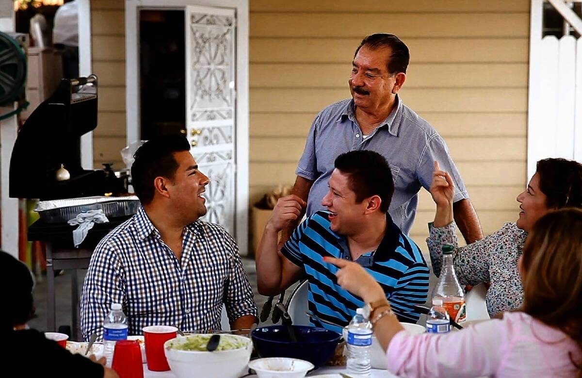 State Sen. Ricardo Lara (D-Bell Gardens), left, laughs with his nephew, Ernesto Lara, center front, his father, Venustiano Lara, center back, and his sister, Jackie Lara, right, during a cookout at his parents' home in East Los Angeles.