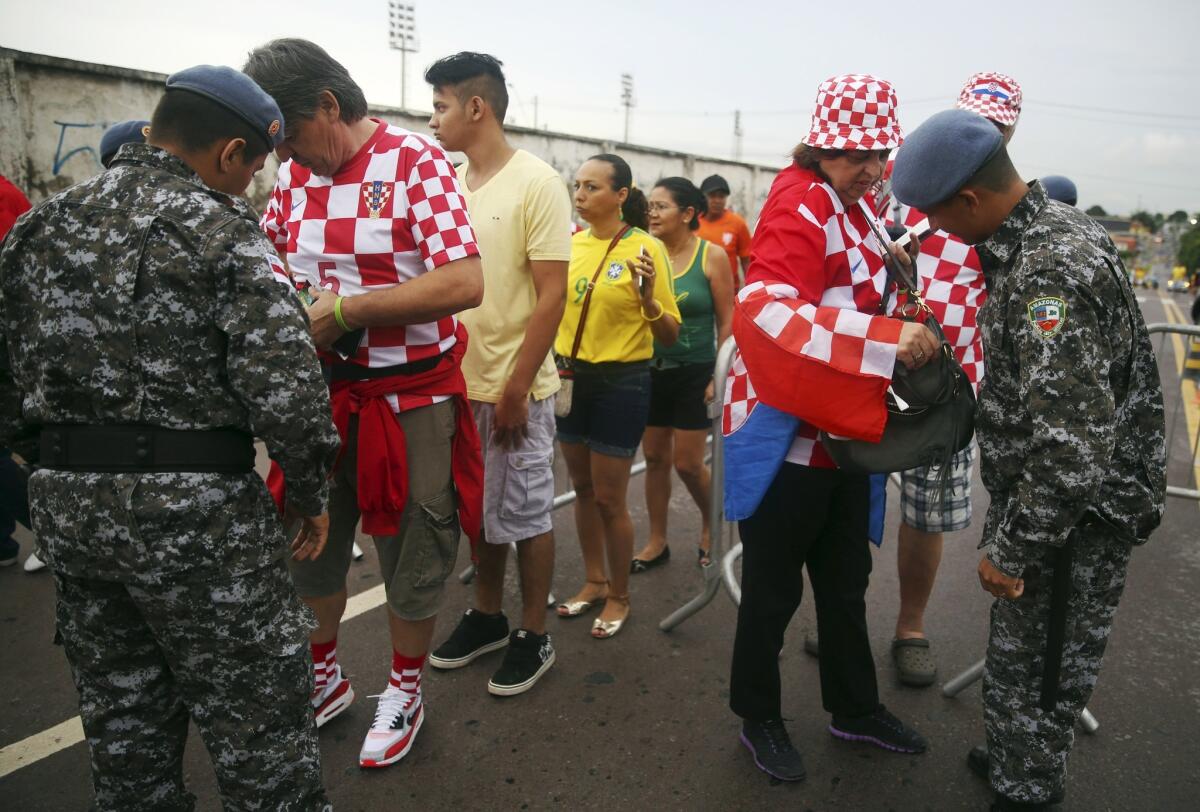 Fans are checked by security personnel before entering the Arena da Amazonia for a Group A World Cup match between Cameroon and Croatia on June 18.