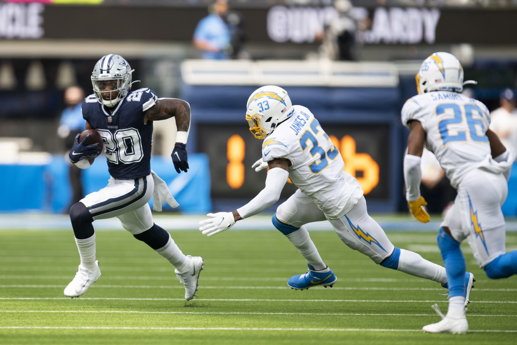 Dallas Cowboys running back Tony Pollard sprints past Chargers free safety Derwin James.