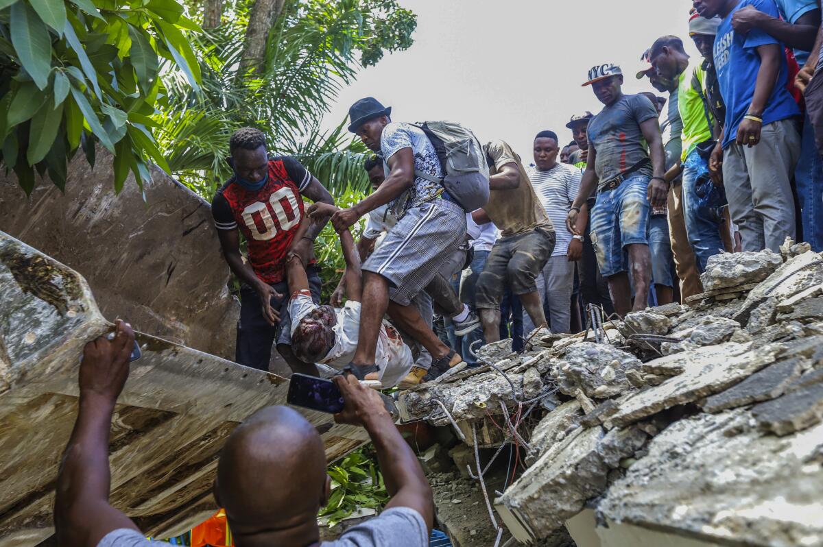 People recover the bodies from the rubble of the Hotel Le Manguier in Les Cayes, Haiti, Saturday, Aug. 14, 2021. 