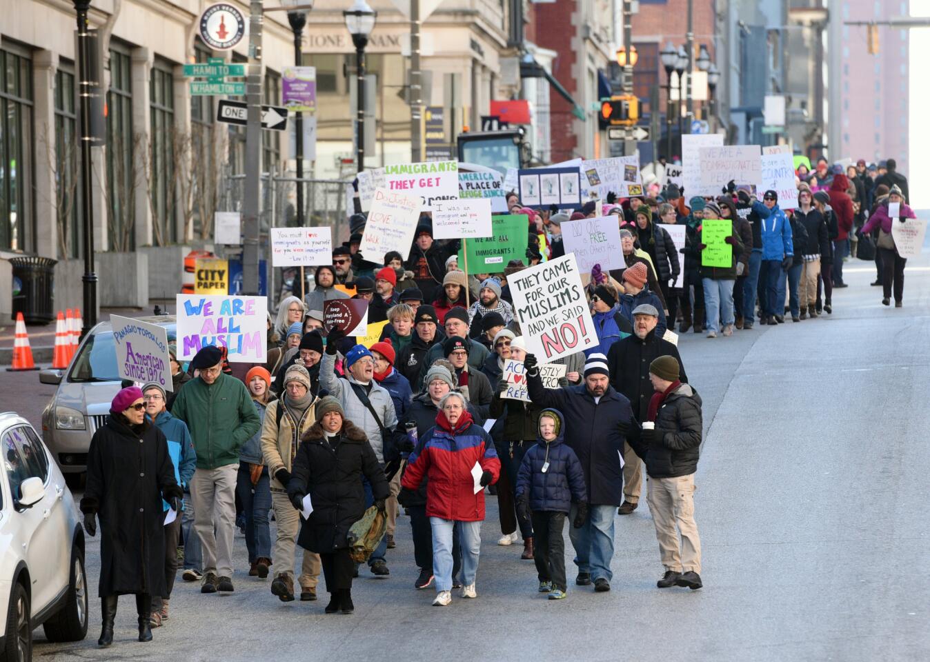 People march along Charles Street Saturday morning to show their support for refugees and call for a permanent end to the temporary travel ban. They are marching three miles from St. Paul's Episcopal Church to the Cathedral of the Incarnation.