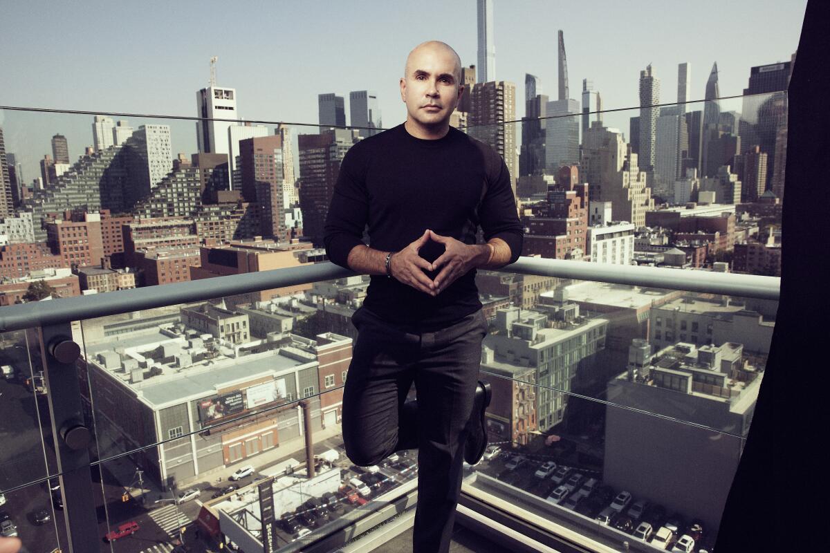 A man stands in front of a city skyline.