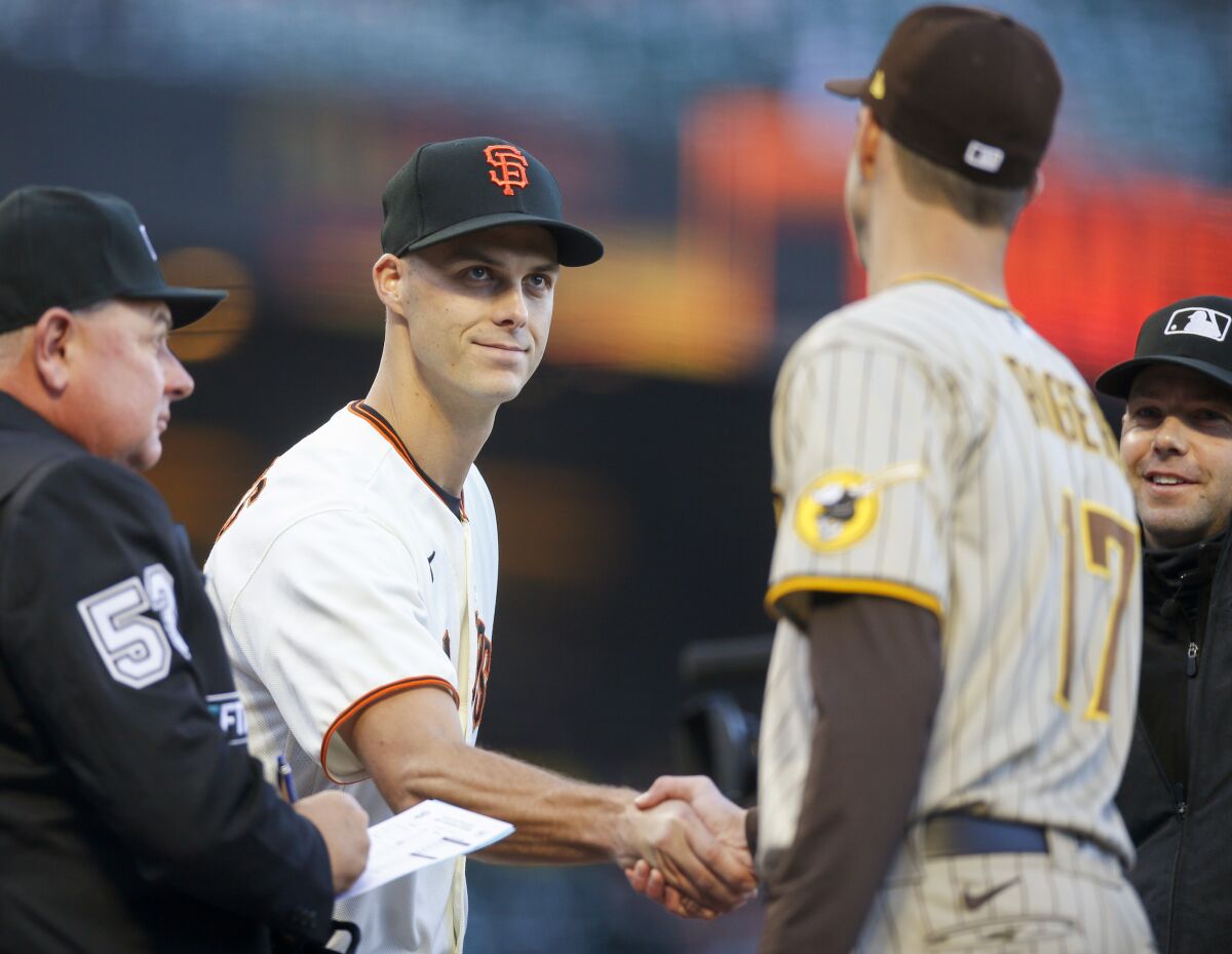 San Francisco Giants' Tyler Rogers (71) shakes hands with his brother San Diego Padres' Taylor Rogers (17) as they exchange lineups before their game in San Francisco, on Monday, April 11, 2022. (Nhat V. Meyer/Bay Area News Group via AP)