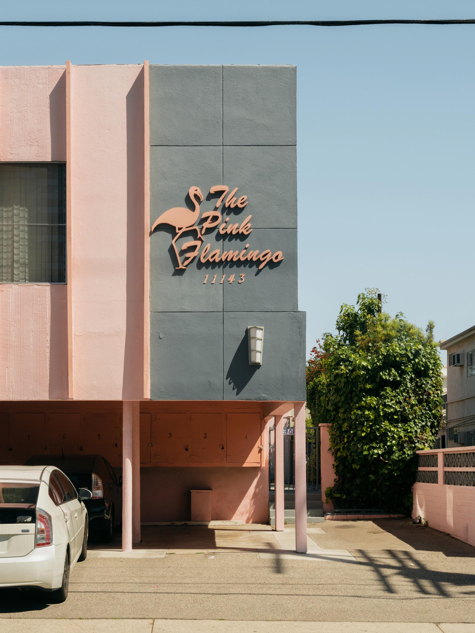 Apartment building sign that reads “The Pink Flamingo 11143”