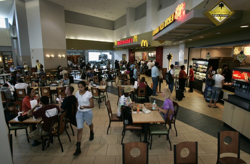 Seating area in food court with McDonalds and California Pizza Kitchen at San Diego International Airport.