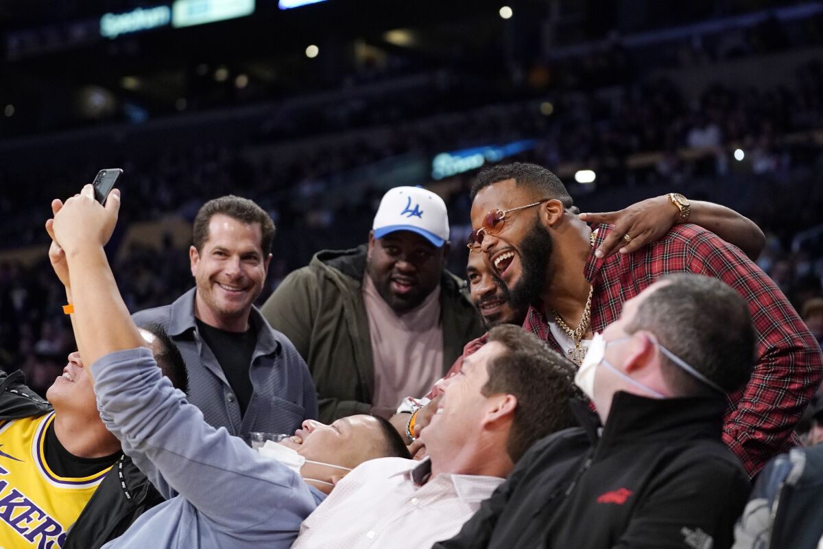 Aaron Donald of the Los Angeles Rams, upper right, poses with fans during the second half of an NBA basketball game between the Los Angeles Lakers and the Utah Jazz Wednesday, Feb. 16, 2022, in Los Angeles. The Lakers won 106-101. (AP Photo/Mark J. Terrill)