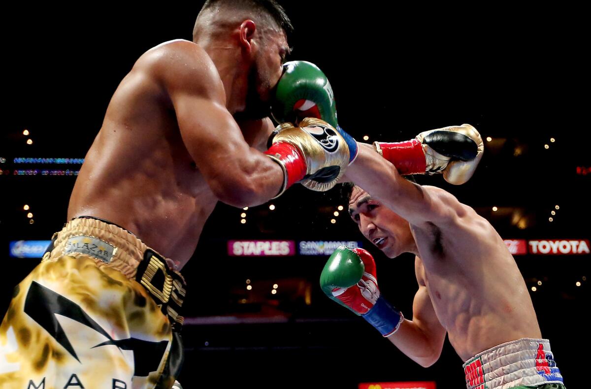 Leo Santa Cruz, right, lands a left jab against Abner Mares during their featherweight bout at Staples Center on Saturday night.