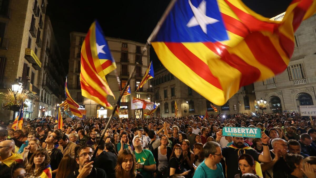 People wave Catalan independence flags after listening to a 9 p.m. statement by regional president Carles Puigdemont.