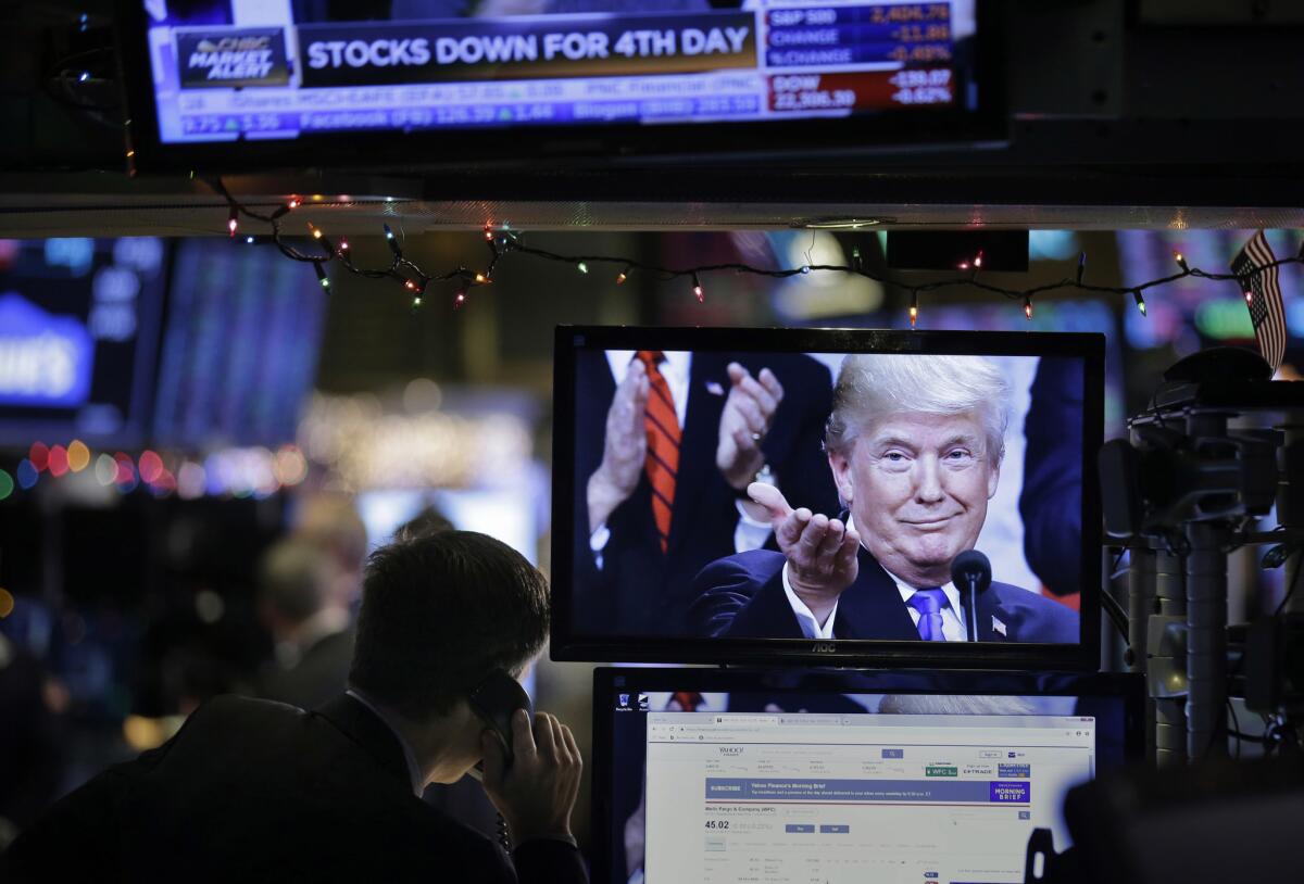 A picture of President Trump is displayed on a computer on the floor of the New York Stock Exchange as investors dumped shares Monday.