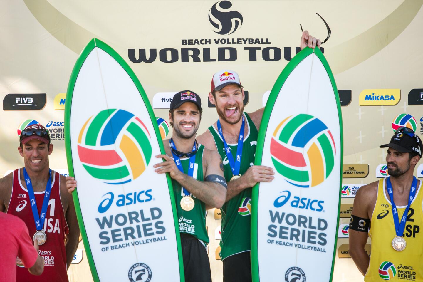 Bruno Schmidt, left, and Alison Cerutti celebrate atop the podium after winning the ASICS World Series of Beach Volleyball on Sunday in Long Beach.