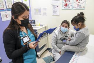 Lynwood, CA - February 25: Medical assistant Maribel Perez, left, attends to Leisure Picon, 35, and 3-year-old daughter Ivanka Mendoza at Eisner Health Clinic on Friday, Feb. 25, 2022 in Lynwood, CA. (Irfan Khan / Los Angeles Times)