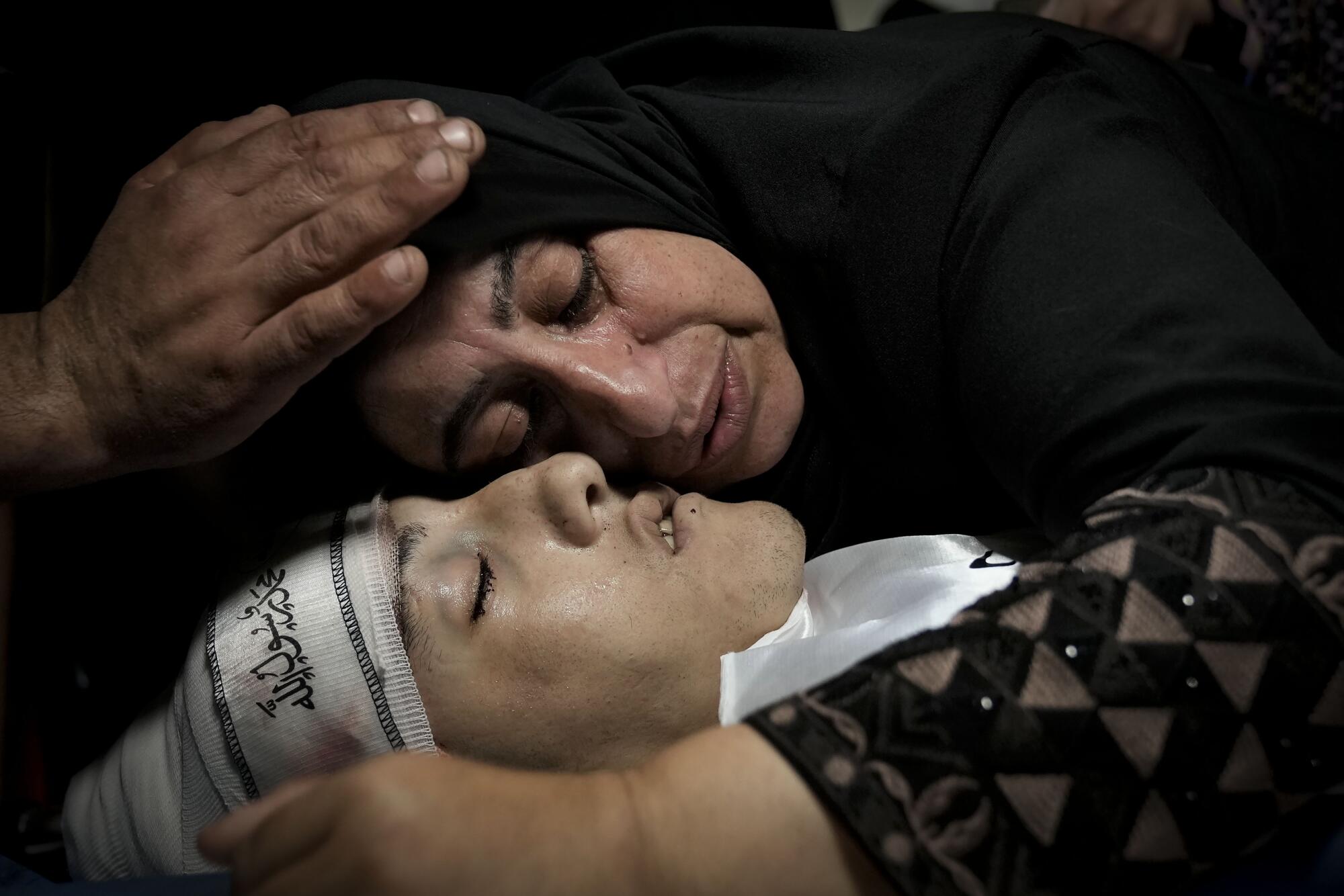 Palestinian relatives mourn over the body of a woman who was killed.