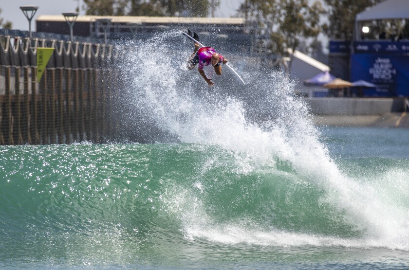 Kelly Slater attempting an aerial high over a wave.