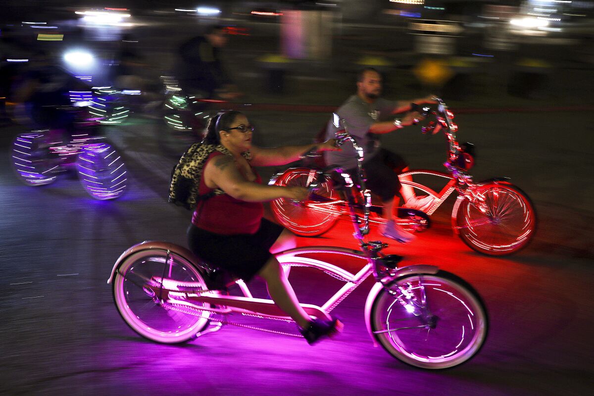 Night shot of people riding bicycles with colorful lights 