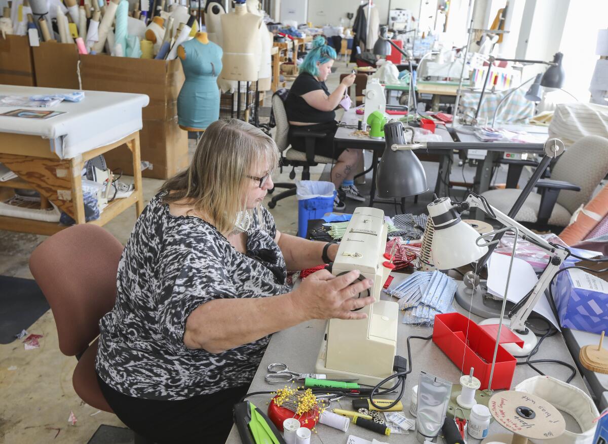 San Diego Opera costume shop manager Ingrid Helton, foreground, and her daughter Delpha Hanson, background, make face masks for the needy at the Opera's costume shop on May 7 in downtown San Diego.