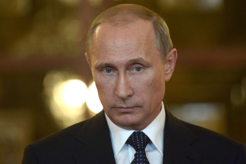 Russia's President Vladimir Putin looks on while speaking with journalists in Itamaraty Palace in Brazilia, early on July 17, 2014.