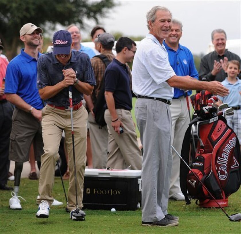 Former President George W. Bush, right, smiles after teeing off at the start of the Patriot Golf Day weekend at Ridgewood country club Friday, Sept. 3, 2010, in Waco Texas. Standing next to Bush is Maj. Dan Rooney, center, and veteran Heath Calhoun, far left. (AP Photo/ Waco Tribune-Herald, Rod Aydelotte)