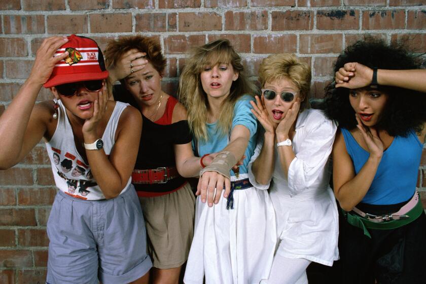 HOLLYWOOD, CA - 1985: The all girl pop musical group the Go-Go's (L-R) Belinda Carlisle (lead vocals), Gina Schock (drums), Charlotte Caffey (lead guitar), Kathy Valentine (bass), Jane Wiedlin (rhythm guitar) make funny faces over Caffey's broken wrist during a 1985 Hollywood, California studio photo session. The band, whose music features a blend of '60s surf, punk and vocal harmonies, took a hiatus while they waited for Caffey's wrist to heal. (Photo by George Rose/Getty Images)
