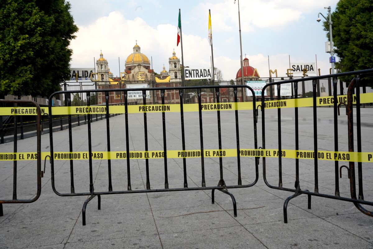Street barricades keep crowds away from Mexico City's iconic shrine of Our Lady of Guadalupe this weekend.