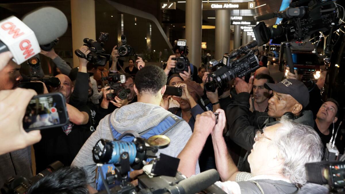 UCLA basketball player LiAngelo Ball is surrounded by a phalanx of cameras as he returns from Shanghai, China at LAX.